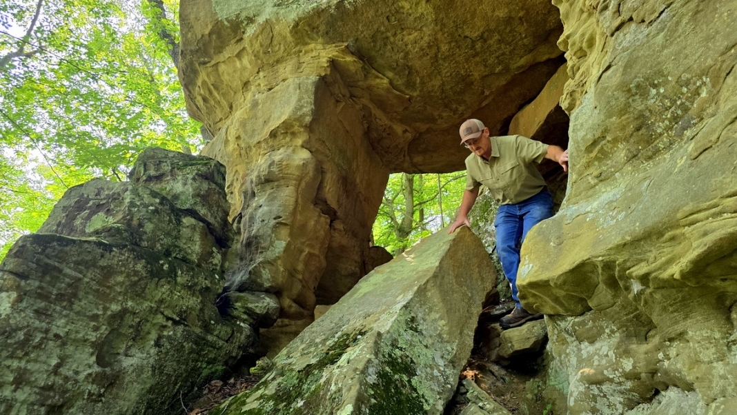 Wind Caves at Camp Kootaga Wind Caves at Camp Kootaga: foundation member Tim Nolan climbs through a sandstone arch.